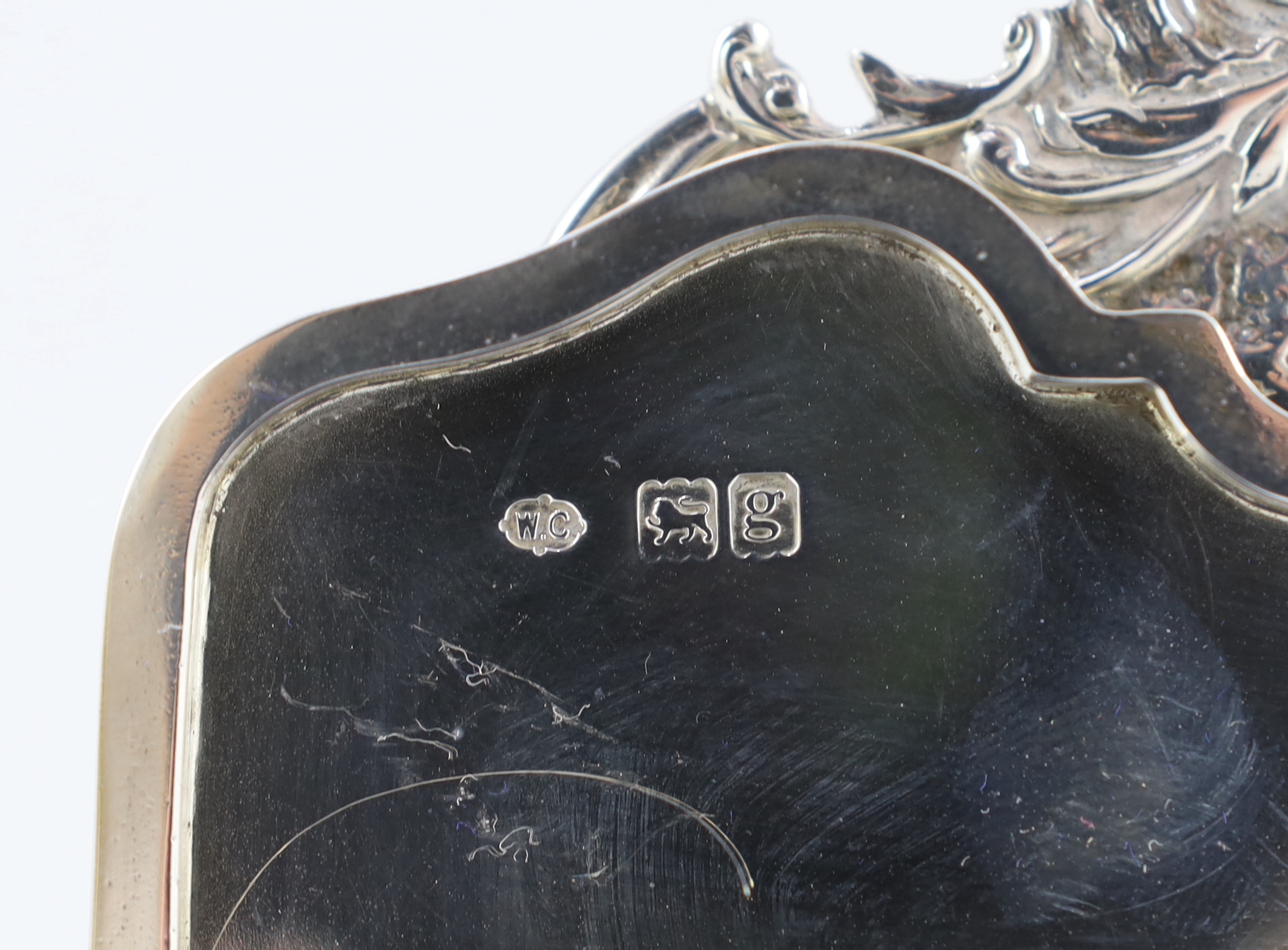 An Edwardian embossed silver novelty trinket box, modelled as a dressing table with raised back, on cabriole legs, by William Comyns